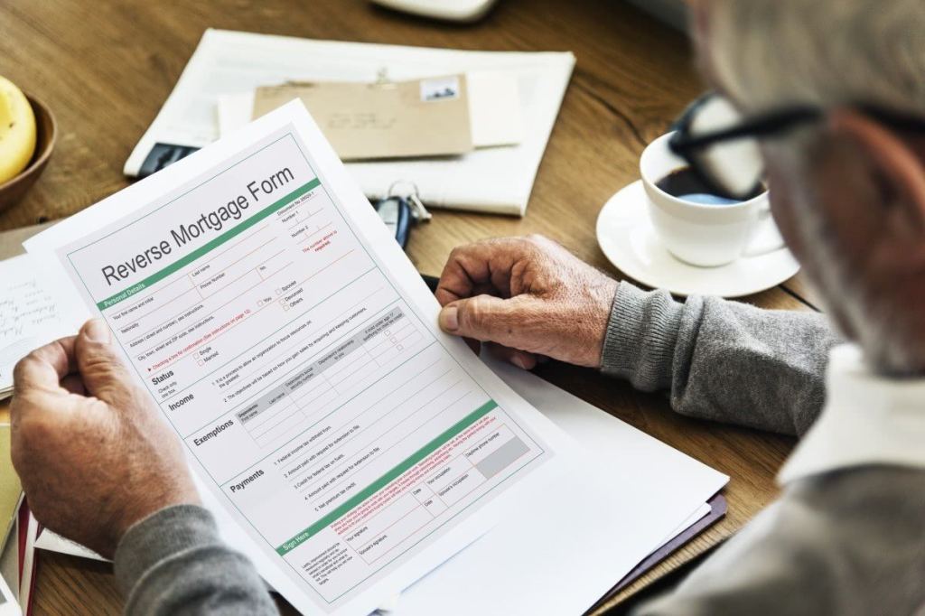 Senior man with bad credit looking at a Reverse Mortgage Form